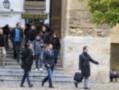 Un grupo de personas caminan por las escaleras del patio de la Catedral de Córdoba, con una placa que dice "Artesanía Los Patios" en el fondo.