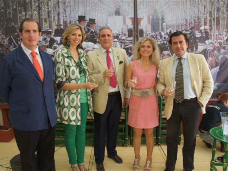 Grupo de personas posando en una presentación, con un fondo que parece ser un evento histórico o deportivo.