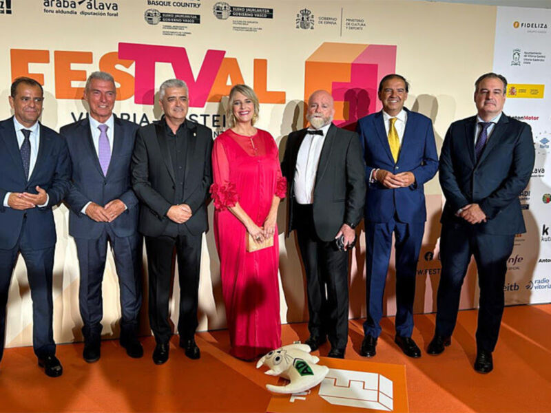 Grupo de personas posando en un escenario con el logo del Festival de Alava al fondo.