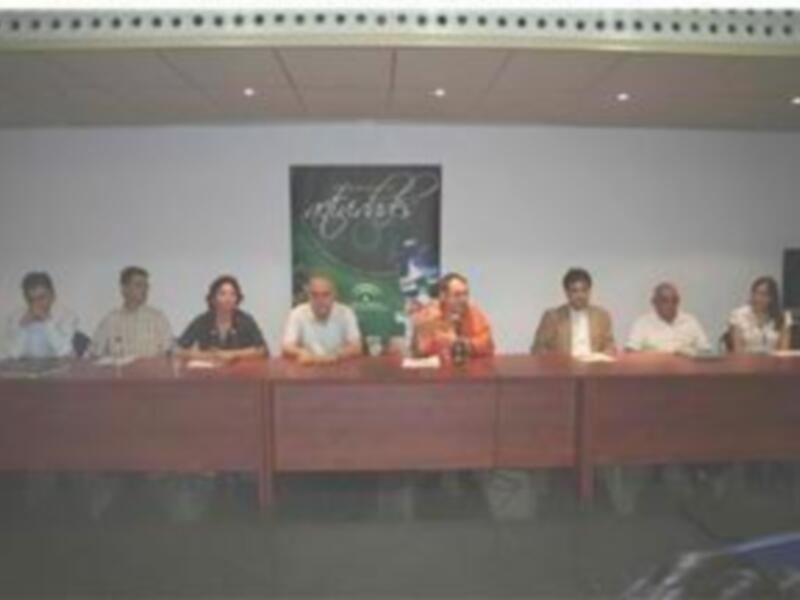Una reunión de negocios en un salón de conferencias con una mesa de conferencias y una pancarta en el fondo.