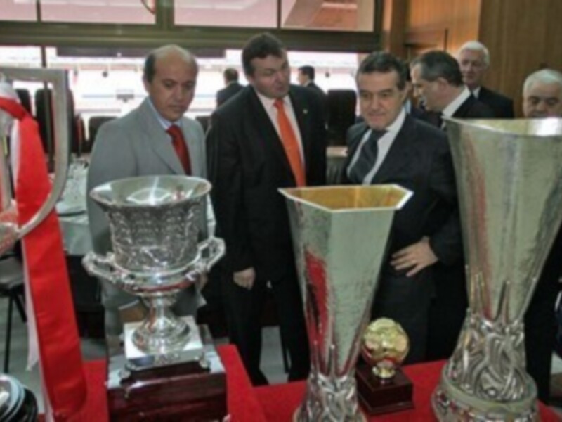 Gente mirando trofeos en una sala de conferencias