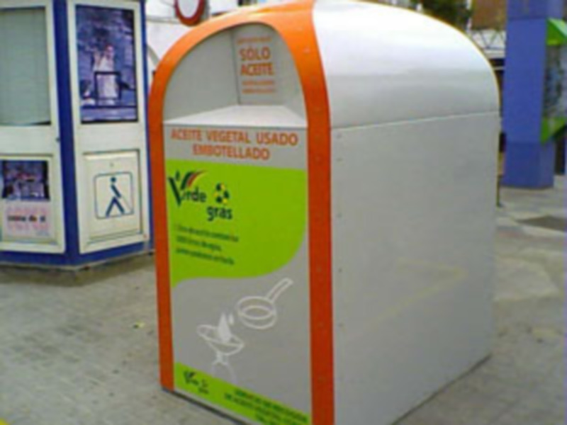 Contenedor para reciclaje de aceite vegetal usado, ubicado en una calle urbana.