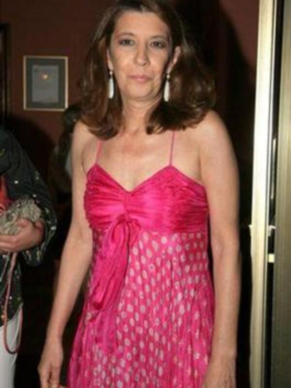 Una mujer con vestido rosa y pendientes en una fiesta de noche.