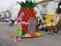 Carroza de dibujos animados en un desfile navideño, con personajes de SpongeBob y Patrick Star en trajes de disfraces.