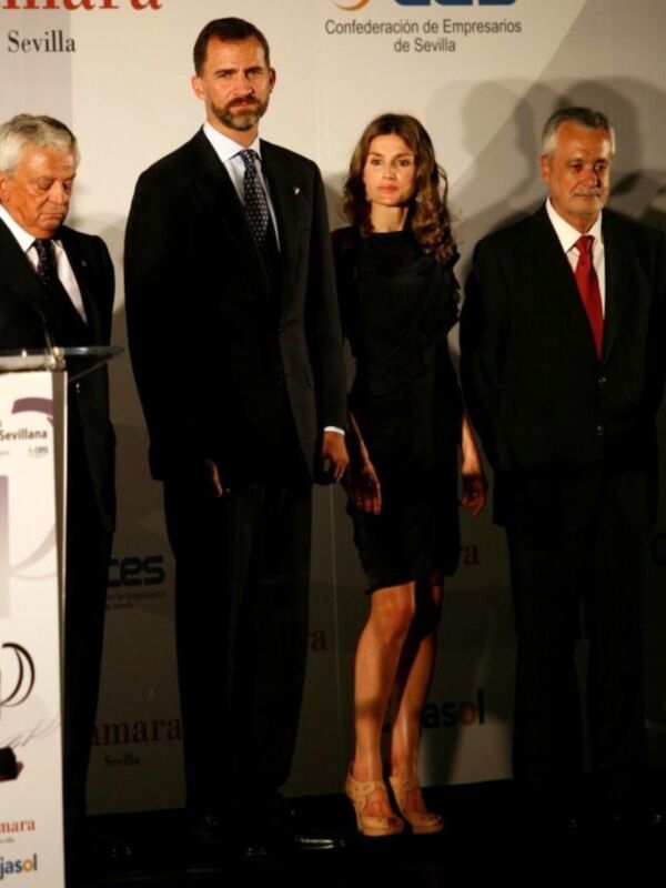 A tres personas posando en una presentación oficial. La persona central es una mujer con vestido negro y zapatos de tacón, flanqueada por dos hombres en trajes formales. El contexto sugiere una celebración o evento de importancia, posiblemente relacionado con la Confederación de Empresarios de Sevilla.