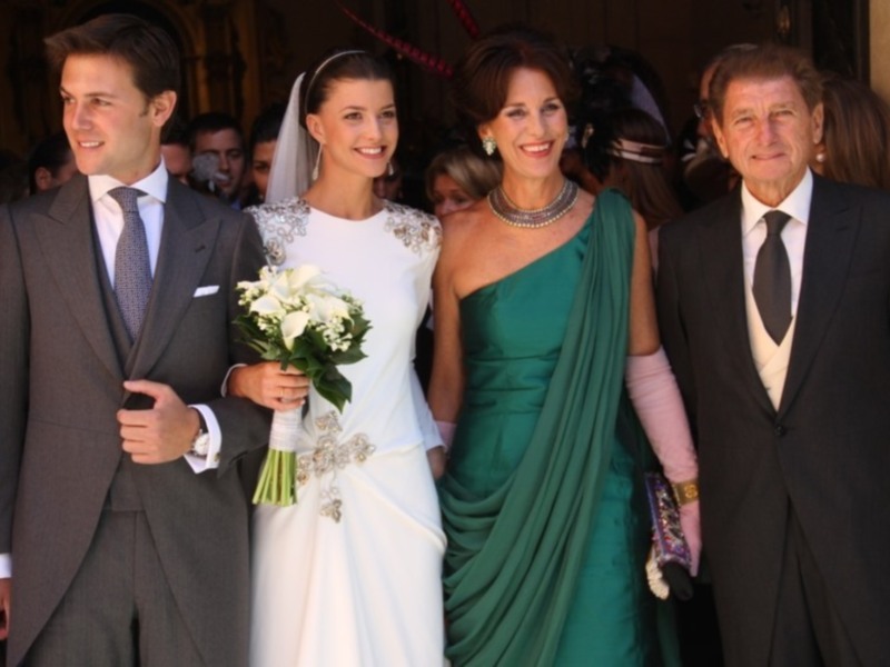 Una boda con una novia en un vestido blanco, un padrino y una madrina en trajes formales.