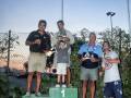 Los ganadores de un torneo de tenis celebran en el podio, con trofeos y medallas.