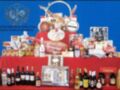 Un hermoso display de productos gourmet y bebidas en una mesa roja, con un fondo azul y la logotipo de la Hermandad de la Vera Cruz.