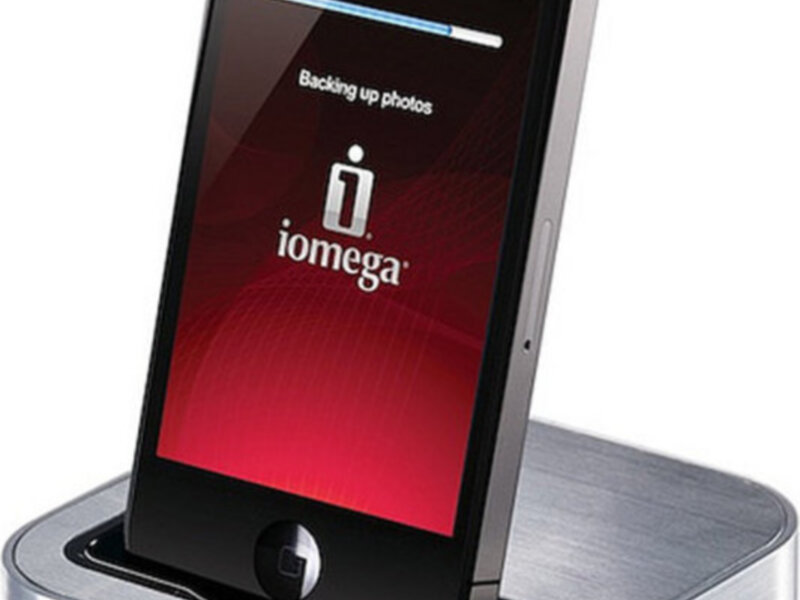 Dispositivo Iomega para sincronización y carga de un iPhone 4 en una base de metal.