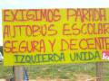 Cartel amarillo con texto en rojo y verde pidiendo parada segura para autobús escolar.
