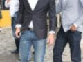 Dos hombres en trajes y jeans, uno con una camisa blanca y el otro con un blazer gris claro.