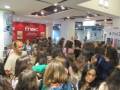 Una multitud de personas en una tienda Fnac, con carteles promocionales y un iPad 2 visible.