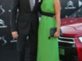 Un hombre y una mujer posan frente a un Citroën, con el hombre vestido de negro y la mujer en un vestido verde.