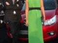 Dos personas posan frente a un Citroën DS3 en una presentación. La persona de la izquierda lleva traje negro y corbata, mientras que la de la derecha está vestida con un vestido verde largo. El fondo muestra el logo de Citroën y el DS3 rojo.