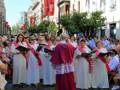 Gente cantando en una procesión religiosa en la calle.