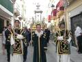 Personas vestidas con trajes tradicionales marchando por una calle.