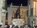 Procesión religiosa con imágenes procesionales en un entorno urbano nocturno.