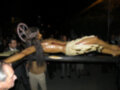 Procesión religiosa nocturna con imagen de Cristo en la cruz, rodeada por fieles observadores.