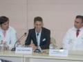 Tres médicos en una conferencia médica, con nombres escritos debajo de sus nombres.