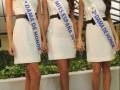 Tres mujeres vestidas con vestidos blancos y corbatas de honor, una con el título "Dama de Honor" y otra con "Miss España 2013".