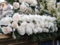 Arreglo floral de rosas blancas y guirnaldas de flores sobre un ataúd, decoración funeraria.