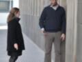 Dos personas conversan en un pasaje urbano, uno apoyado en una pared.