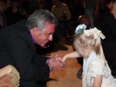 Un hombre y una niña disfrutan de un momento de danza en una celebración.