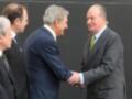Un momento de encuentro entre tres hombres en trajes, uno de ellos estrechando la mano del otro.