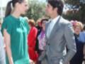 Dos personas se encuentran en una fila de personas vestidas formalmente. La mujer, con un vestido verde, y el hombre, con una chaqueta gris, se miran directamente. La escena parece ser un evento formal o ceremonial.