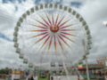 Ferris wheel at an amusement park under a partly cloudy sky.