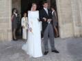Una boda en un edificio histórico, con una novia en vestido blanco y un novio en traje negro.
