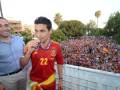 Un jugador de fútbol español con la camiseta número 22 celebra junto a un hombre en una tribuna llena de espectadores.