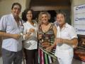 Una familia feliz en una fiesta, con un hombre y una mujer sosteniendo una botella de cerveza, mientras otra pareja sostiene un libro.