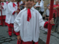 Un individuo vestido con un traje tradicional blanco y rojo, posiblemente durante una celebración o ceremonia cultural.