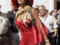 Una mujer vestida de rojo con un sombrero y una bufanda, caminando entre personas.