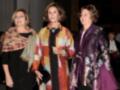 Tres mujeres vestidas con elegantes abrigos, posiblemente en un evento formal.