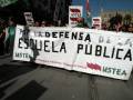 Protesta de trabajadores públicos en Andalucía, con pancartas y banderas políticas.