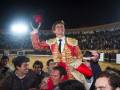 Triunfante torero celebrando con el público en una corrida de toros.