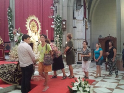 Una imagen de una iglesia con un altar adornado y varias personas en el coro, posiblemente durante una ceremonia religiosa.