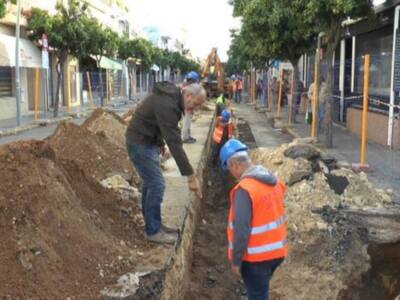 Trabajadores en construcción de una calle, con herramientas y equipo.