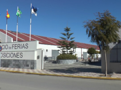 Palacio de Ferias y Exposiciones, con banderas ondeando en el cielo azul.