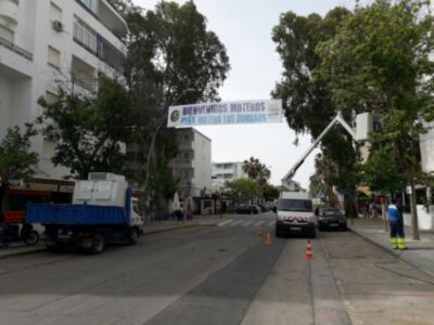 Trabajos de mantenimiento en la calle, con una grúa y trabajadores en el camino.