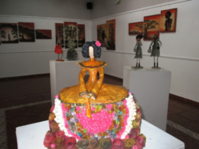 Escultura artística con motivos florales y figuras humanas en una exposición de arte.
