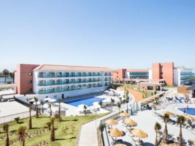 Hotel moderno con piscina y áreas verdes, ubicado en una zona tranquila.