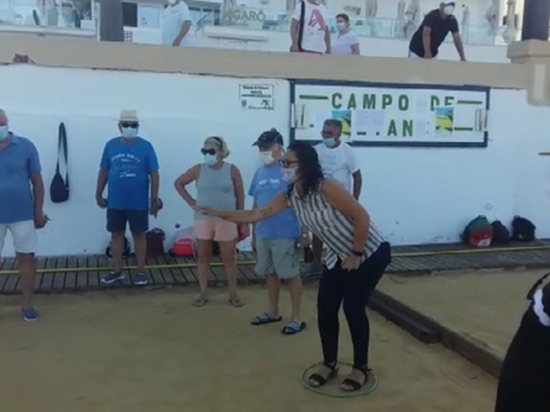 Un grupo de personas con máscaras en un campo de tenis, posiblemente durante una reunión o evento deportivo.