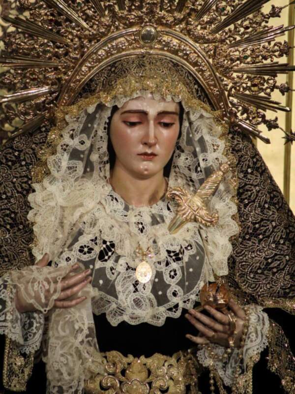 Imagen de la Virgen de la Soledad, una figura religiosa adornada con un manto de luto y una corona de espinas, representando su dolor y sufrimiento.