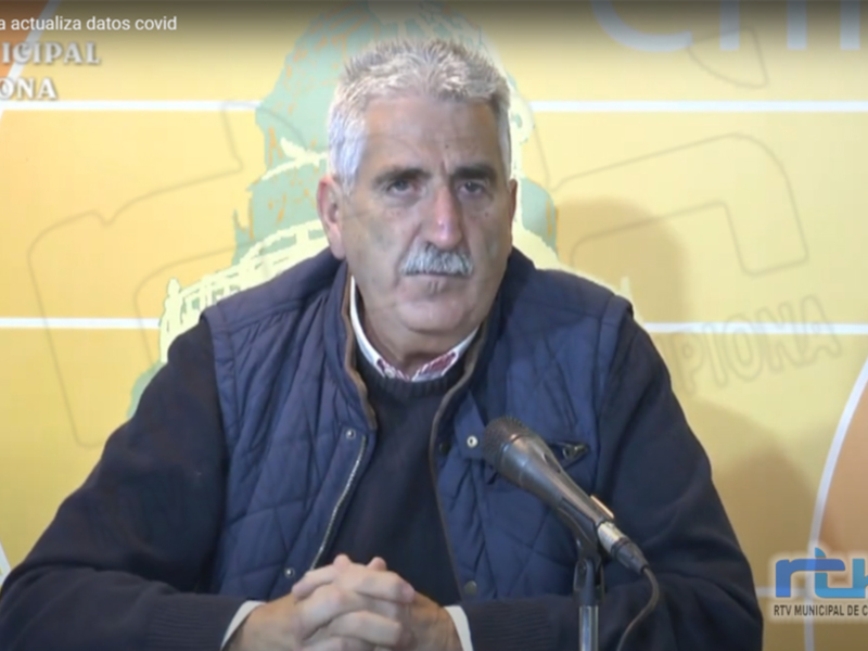 Hombre hablando en una conferencia de prensa con un fondo amarillo y la palabra 'Chipiona' en el centro.