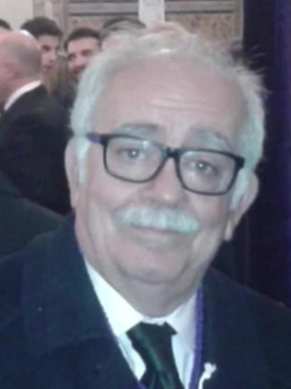 Un hombre con gafas y una barba blanca, posando para la cámara.
