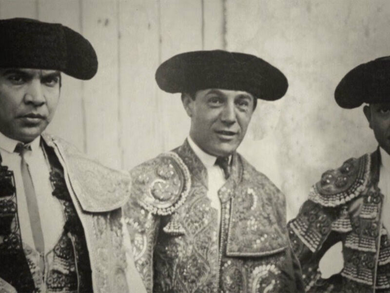 Tres toreros vestidos con trajes tradicionales, posando para una foto en blanco y negro.