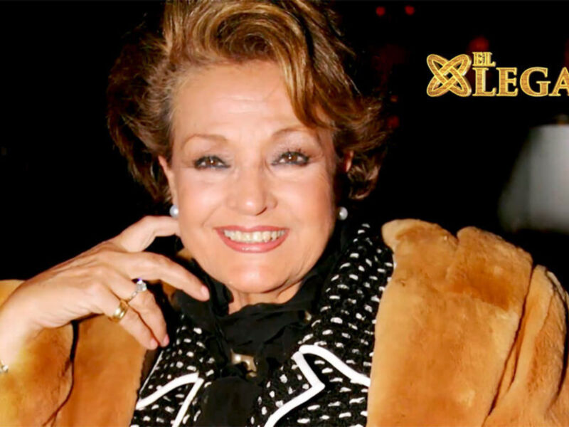 A una mujer sonriendo ampliamente, con un fondo borroso que parece ser una escena nocturna. La mujer lleva una chaqueta de terciopelo marrón y un tocado con flecos. En la imagen se puede ver el logo de "El Legado" en la parte superior derecha.